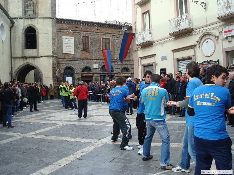 Partecipanti al tiro alla fune in piazza, circondati dal pubblico